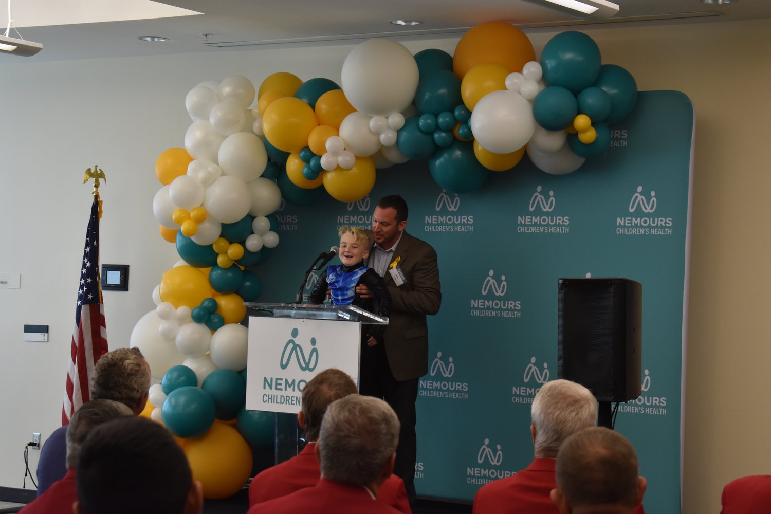 John Fischer holds up his son Rhett to say a few words to the crowd during the press conference.